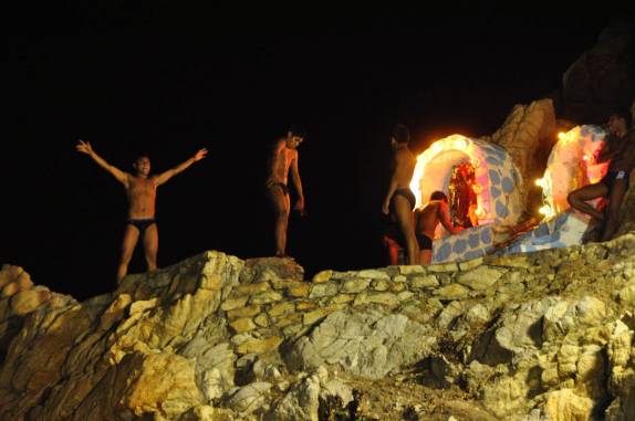 Uns posam para fotos enquanto outros oram antes do salto em La Quebrada, em Acapulco, no México